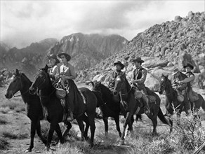 Walter Brennan (left), Virginia Mayo, Kirk Douglas (far right), on-set of the western film, "Along