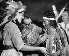 Suzan Ball (left), John Sitting Bull being given a hearing aid (left), on-set of the western film,