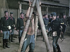 Michael Cole (being flogged), on-set of the western film, "Chuka", Paramount Pictures, 1967