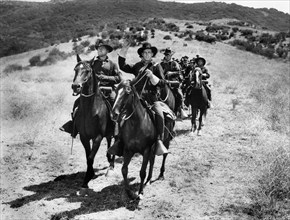 James Whitmore (foreground, left), Guy Madison (foreground, right), on-set of the western film,