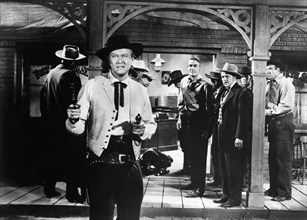 David Brian (foreground), Randolph Scott (background center), on-set of the western film, "Fort