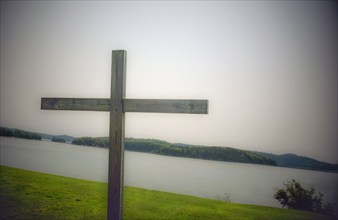 Wood cross on grass overlooking bay, Castine, Maine, USA