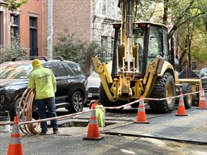 Infrastructure maintenance worker with excavator, street scene, Greenwich Village, New York City,