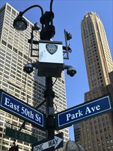 Low angle view of two office buildings with police security cameras attached to lamppost with