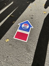 High angle view of human shadows near NYC board of elections early voting arrow sign adhered to