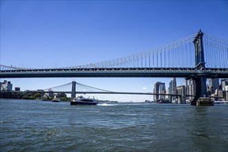 Manhattan (foreground) and Brooklyn (background) bridges crossing over East River with downtown