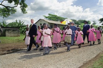 U.S. President Bill Clinton and U.S. First Lady Hillary Rodham Clinton walk with school children,