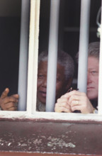 U.S. President Bill Clinton and South African President Nelson Mandela looking out from Cell Block