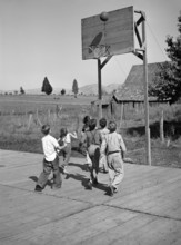 Group of children playing basketball at Farm Security Administration (FSA) mobile camp for