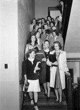 Group of young adult women in stairwell between classes in Home Economics building, Iowa State