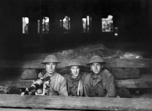 Three U.S. soldiers with machine gun set up in railroad shop, Company A, Ninth Machine Gun