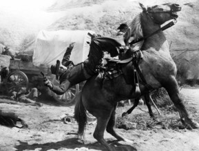 Cattle rustler being shot on horseback, on-set of the western film, "Gun For A Coward", Universal