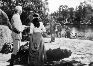 Glen Langan (rear view, left), Brenda Marshall (rear view, 2nd left), on-set of the western film,