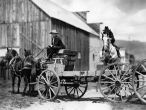 Fred Thomson (jumping over wagon on horse), on-set of the silent western film, "Jesse James",