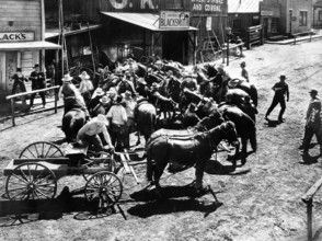 Harry Carey, Walter Huston (with rifles fending off mob), on-set of the western film, "Law And