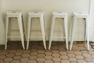 Four white metal stools