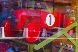 Large red toy car in store window