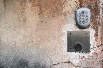 Metal numeric entryway keypad on textured wall