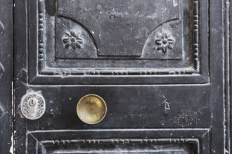 Old black wood door with gold-colored door knob