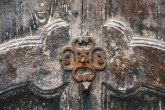 Rusted door ornament on carved wood door