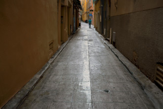 Rear view of man walking through alley, Vieux Nice, Nice, France