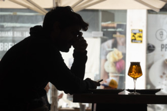 Silhouette of mid-adult man looking at his smartphone at café