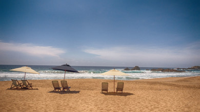 Beach chairs and sun umbrellas on sandy beach, Mexico