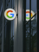 Google store at night, close-up view of illuminated company logo on building exterior, New York