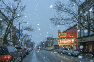 Snowy street scene with illuminated movie theater marquee, Traverse City, Michigan, USA