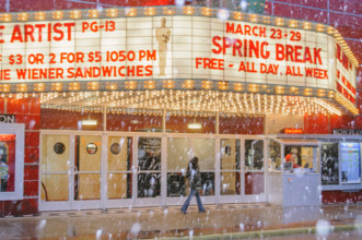 Illuminated movie theater marquee on snowy day, Traverse City, Michigan, USA