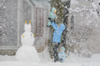 Mother playing with her two children in snow