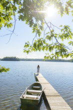 Rear view of adult woman standing at end of dock