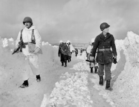 U.S. infantrymen of an armored division marching up snowy road southeast of Born, Belgium, U.S.