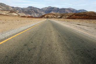 Asphalt road with mountains in background, diminishing perspective, Death Valley National Park,