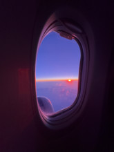 Purple sunset viewed through airplane window
