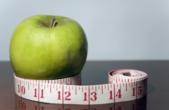 Green apple with tape measure