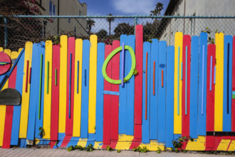 Colorful painted wood boards attached to chainlink fence