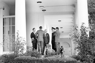 U.S. President John F. Kennedy (back view) speaking with (L-R) Special Assistant to the President