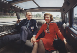 U.S. President Gerald Ford and U.S. First Lady Betty Ford holding hands while riding in the