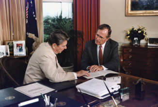 U.S. President Ronald Reagan and U.S. Vice President George H.W. Bush working in the Oval Office,