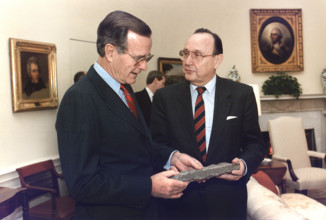 U.S. President George H.W. Bush is presented with a piece of the Berlin Wall by West German Foreign