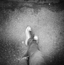 High angle view of mid-adults man's legs wearing jeans and sneakers