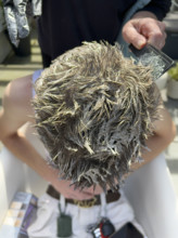 High angle view of young adult man getting his hair bleached