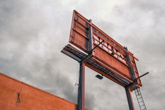 Low angle rear view of weathered billboard at dusk