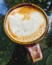 High angle view of brewed cappuccino with milk in cup