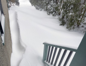View of snowdrifts from back porch of residential home