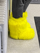 Woman wearing bright yellow furry boots