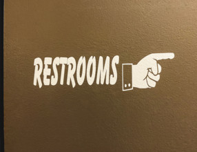 hand symbol pointing way to restrooms