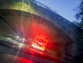 View from car of public school bus as it enters stone bridge tunnel at dusk