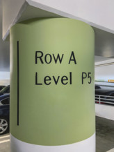 Painted cement column in public parking garage informing customers of their parking location